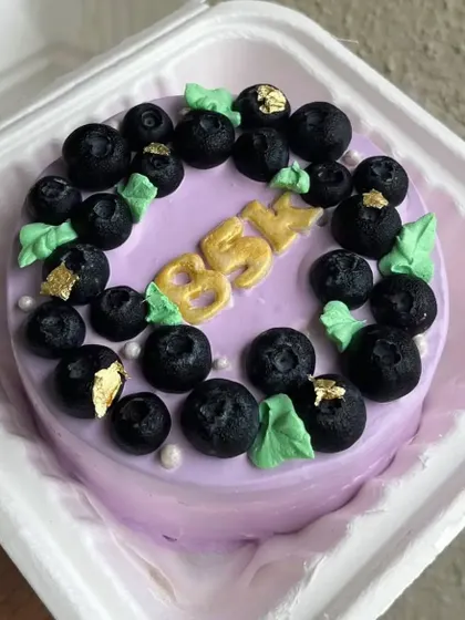 A blueberry bento cake, decorated with fresh blueberries and touches of edible gold leaf for an elegant finish.