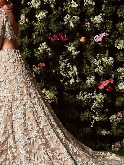 The beauty of a long train. This ivory lehenga is covered in intricate floral threadwork, creating a breathtaking effect that is perfect for a walk down the aisle.