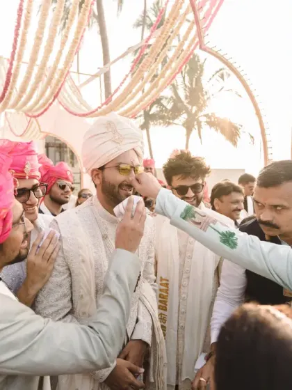 The groom's playful welcome by his friends and family as he arrives for the ceremony. This candid shot is full of the fun and excitement of the baraat.