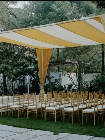This image shows the guest seating area for a modern Haldi. The yellow and white striped canopy provides shade and adds a chic, cabana-like feel to the outdoor event, ensuring guests are comfortable and stylishly accommodated.