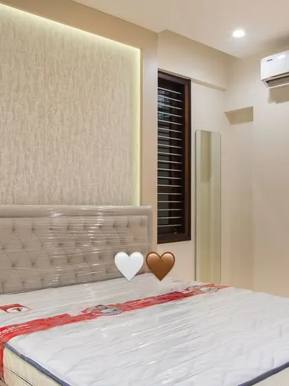 The textured wallpaper behind the bed is highlighted by soft, indirect lighting, creating a warm and welcoming ambiance for guests.