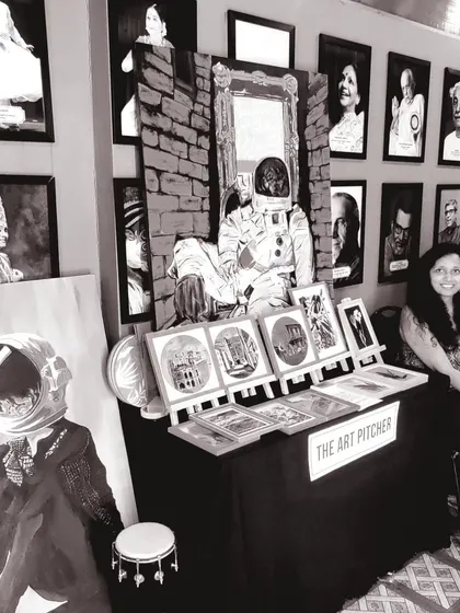 A black and white photo of my stall at a flea market, featuring my astronaut paintings and other framed prints. These events are a great way to showcase my work and connect with the local art community.