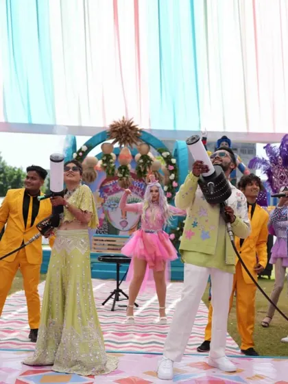 The bride and groom, armed with CO2 guns, lead the party from the front. This is what a high-energy carnival looks like.