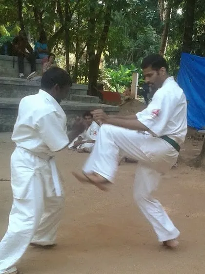An outdoor training session where students practice mae geri, or front kicks. Training barefoot on natural ground helps improve balance and footwork.