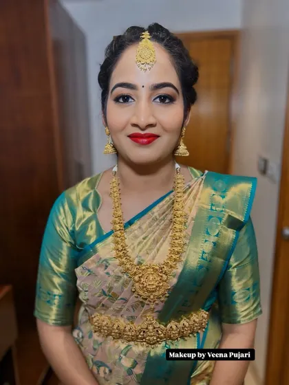 A beautiful smile from a happy client. This traditional look features a classic red lip and softly defined eyes, paired with a gorgeous silk saree for a timeless feel.