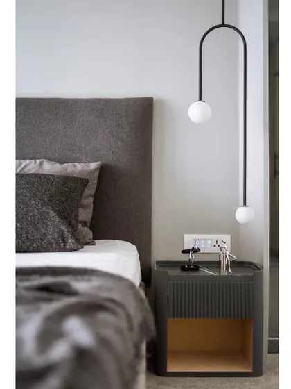 A close-up of the custom bedside table and suspended light. The fluted detail on the table and the simple geometry of the light fixture showcase our attention to craftsmanship and detail.