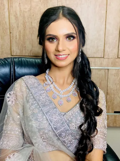 A happy smile from a satisfied client. Her makeup is designed to enhance her features naturally, making her feel comfortable and beautiful.