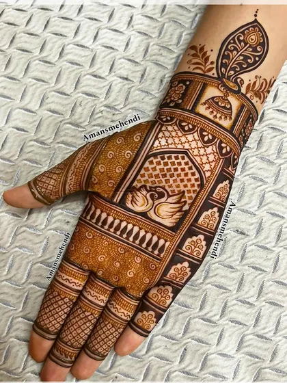 A classic design with a pair of swans in the center of the palm. The wrist is adorned with a jhumka and a peacock feather, adding to the traditional charm.