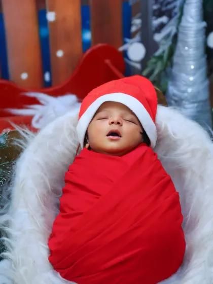 A close-up of the newborn in the Christmas theme, capturing a sweet, sleepy yawn.