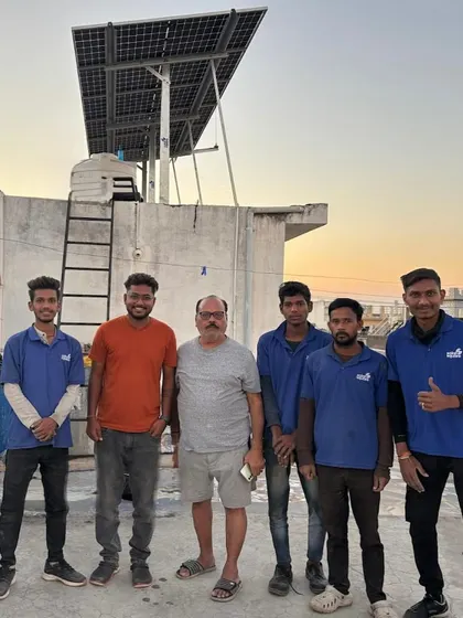 A homeowner stands with our installation crew at sunset, celebrating the completion of his rooftop solar project.