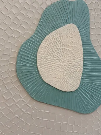 Detail of the outer layer of one of the sculptural pieces, showing a repeating, almost scale-like pattern that adds another layer of complexity to the design.