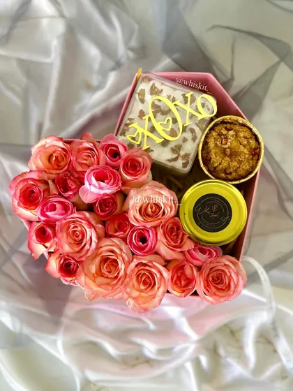 A heart-shaped box with roses, a jarred dessert, and a brownie slab. A perfect combination of flowers and sweets.