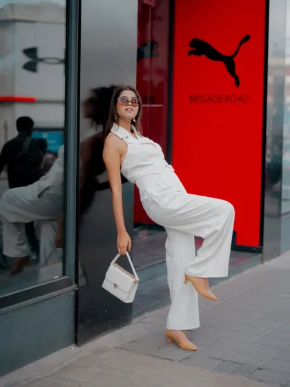 A playful and dynamic pose in front of a Puma storefront. This shot is perfect for a brand collaboration, blending street style with commercial branding in a natural, energetic way.