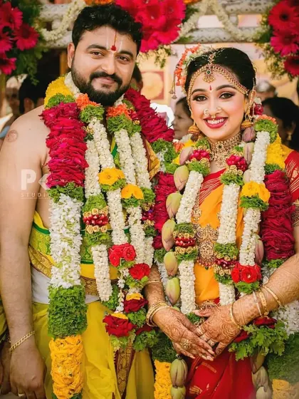Congratulations to this beautiful couple. The bride is glowing in her traditional yellow and red muhurtham saree, with makeup that enhances her natural beauty and happiness.