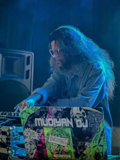 A cool, blue-lit shot of me focused on my mix at a college event.