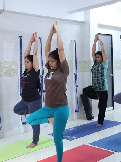 An instructor guides students in Vrikshasana (Tree Pose) during our free offline yoga camp. This balancing pose helps to improve focus, concentration, and physical stability.