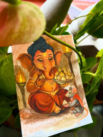 A creative shot of the Ganesha and Mooshika painting, nestled among green leaves, connecting the divine art with nature.
