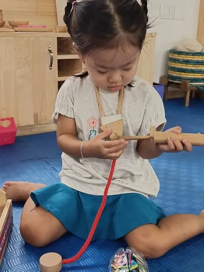 Our role-play zone is one of the most popular areas. Here, a child pretends to be a carpenter, using wooden tools to "fix" things, which helps develop fine motor skills and imaginative thinking.