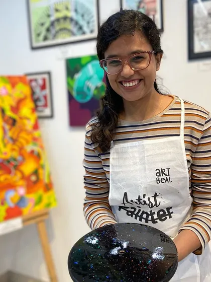 A participant with her finished galaxy resin clock. The deep colors and sparkling details make it a truly eye-catching piece.