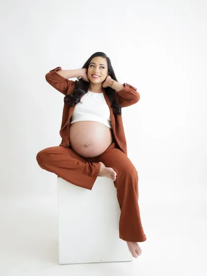 A duplicate of image 191, this joyful and confident portrait features a mom-to-be in a stylish brown suit.