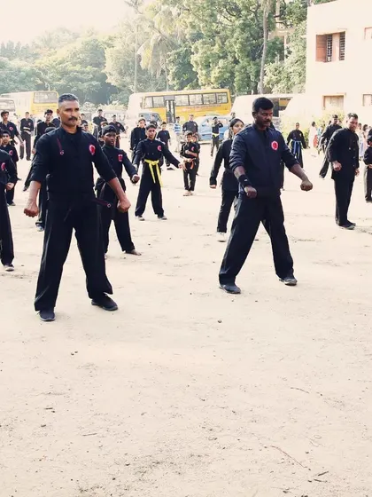Students hold a ready stance during an outdoor combined belt test. This moment of stillness before action is just as important as the movement itself, teaching patience and control.