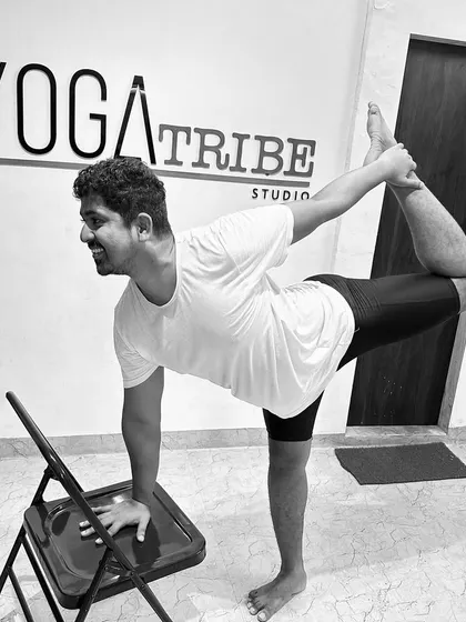 Demonstrating Natarajasana (Dancer's Pose) with the help of a chair. This is a great way to work on your balance and backbend without pressure.
