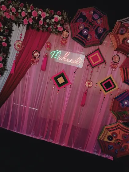 An angled shot of the pink Mehendi setup, showing how the drapes and flowers create a beautiful photo corner.