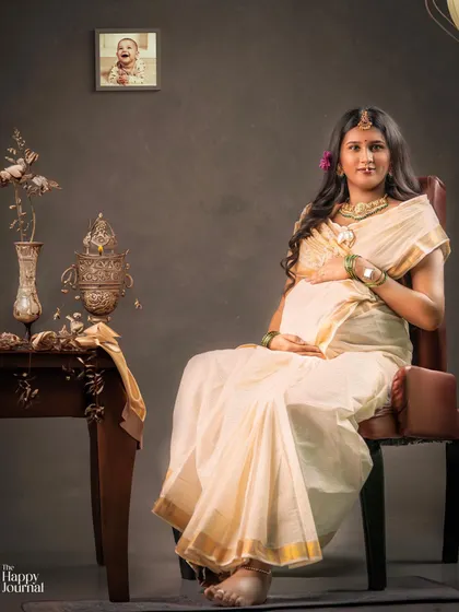 A portrait of a mother-to-be, seated gracefully in a traditional saree. The composition and lighting are crafted to create a fine art look that honors her cultural heritage.