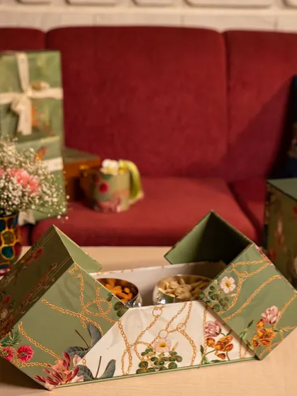 A dry fruit box from the Tales of Tropic collection, showcasing its unique folding design. This piece combines functionality with the collection's signature botanical artistry, making it a delightful and practical gift.