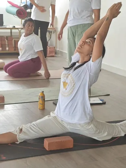 The journey to Hanumanasana (the splits) is one of patience and consistent practice. Here, a student demonstrates incredible flexibility, supported by the use of blocks for proper alignment.