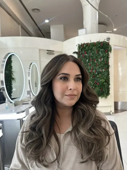The final result of the luxury ash melt brown. This angle shows how the color frames the face and brightens her complexion, even in a salon setting.