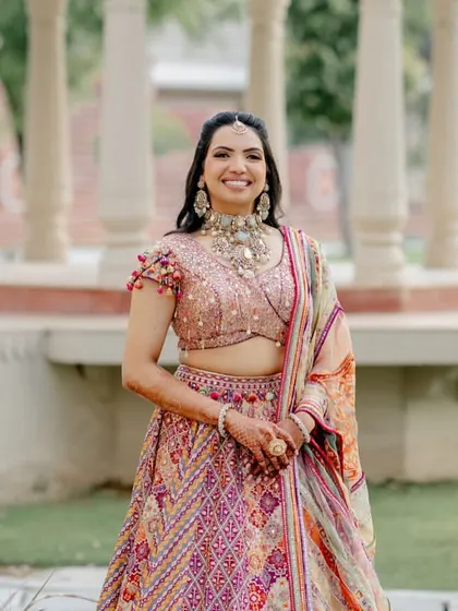 A full-length shot of Nikita's vibrant Tarun Tahiliani lehenga for her Dastoor ceremony. The multi-colored embroidery and playful silhouette were perfect for the occasion.