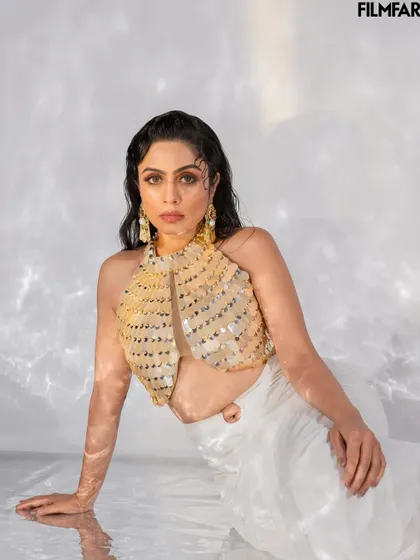 A seated portrait from the Filmfare shoot, focusing on a more intimate and composed mood. The interplay of light and shadow on the water creates a serene yet captivating effect.