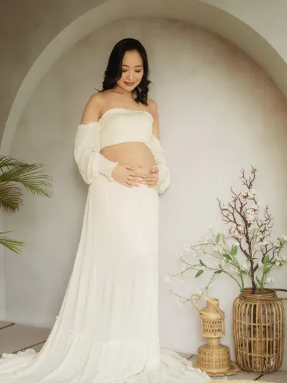 A minimalist and modern solo portrait. The simple white two-piece outfit and clean background create a fresh, contemporary look.