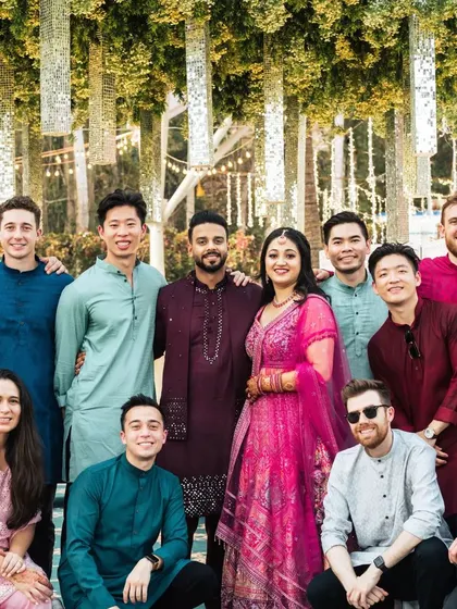 The couple with their international friends at the Sangeet. The decor, with its hanging mirrored tassels, adds a touch of Indian glamour to this multicultural celebration.