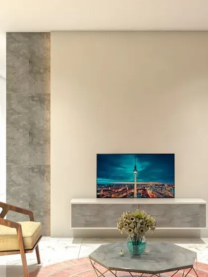 A minimalist living room concept with a simple floating TV console against a concrete-finish accent wall.