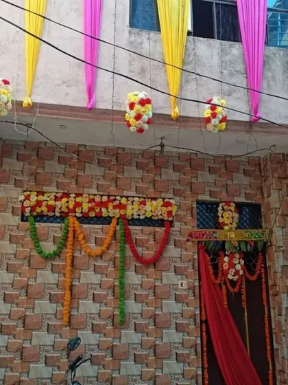 The ground floor entrance of a house decorated with a floral border and marigold garlands to welcome guests.