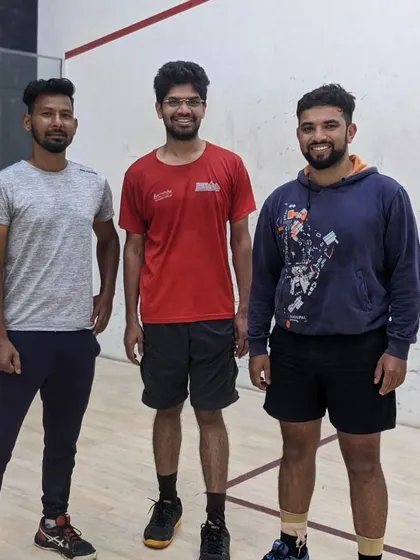 Three of our members posing with a coach after a great session on the squash court. The community is at the heart of everything we do.