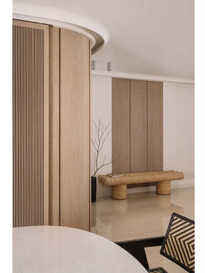 The entrance of Kanso House, where a woven bench and minimalist decor create a simple, pure, and welcoming first impression.