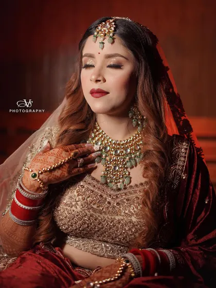 A serene and elegant bridal portrait, capturing the bride with her eyes closed, highlighting the rich details of her velvet lehenga and jewelry.