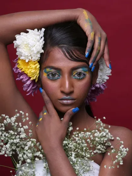 This shot captures the complete artistic vision, with the model's pose echoing the organic shapes of the flowers and makeup.