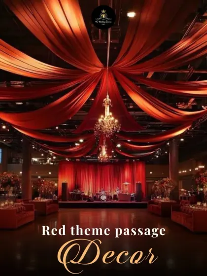 This reception hall entrance features a ceiling of flowing red drapes anchored by a central chandelier. The cohesive red theme creates a bold and passionate atmosphere for a night of celebration.