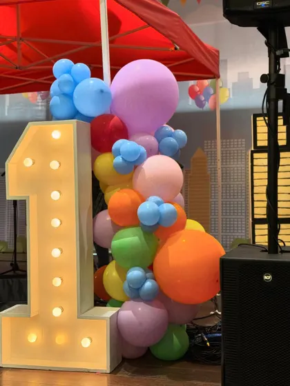 A Central Park-themed first birthday featuring a stunning carousel centerpiece, a candy floss cart, and a large pastel-colored soft play area for endless fun.