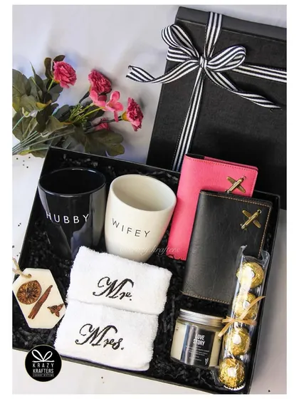 Our popular 'Couple's Combo' hamper, featuring 'Hubby' & 'Wifey' mugs, 'Mr. & Mrs.' towels, personalized passport covers, and a 'Love Story' scented candle.