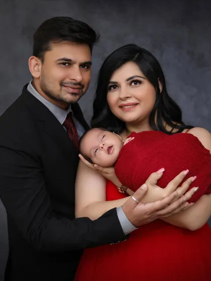 A beautiful close-up of the new family. The baby is awake and looking towards the camera, held securely in the mother's arms, creating a lovely connection.