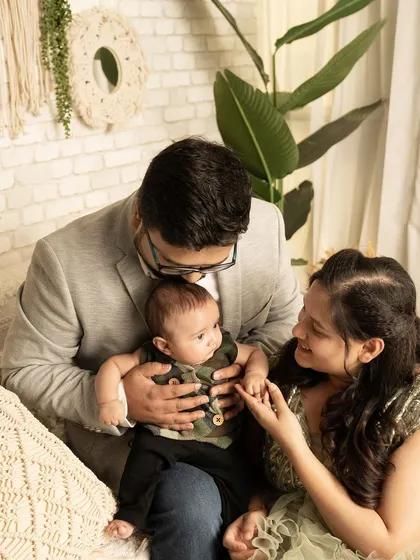 A tender moment between new parents and their baby. The way they look at each other and their child shows the deep love and connection in their new family.