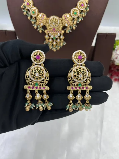 An antique-style necklace set with intricate detailing and multi-color stones, shown from different angles.