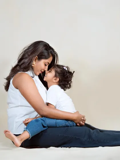 An intimate moment between mother and daughter, sharing a secret or a laugh. Their closeness and smiles tell a story of a special bond.