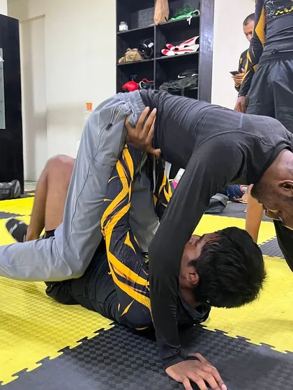 Rolling with purpose, sparring with skill. A student works to pass the guard during a BJJ session. This is where mastery begins.