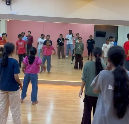 A behind-the-scenes look at a dance workshop, showing the mix of kids and adults learning together.